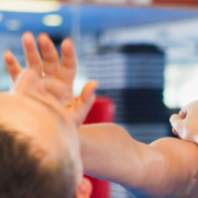 Woman is training with man on the self-defense course in gym.